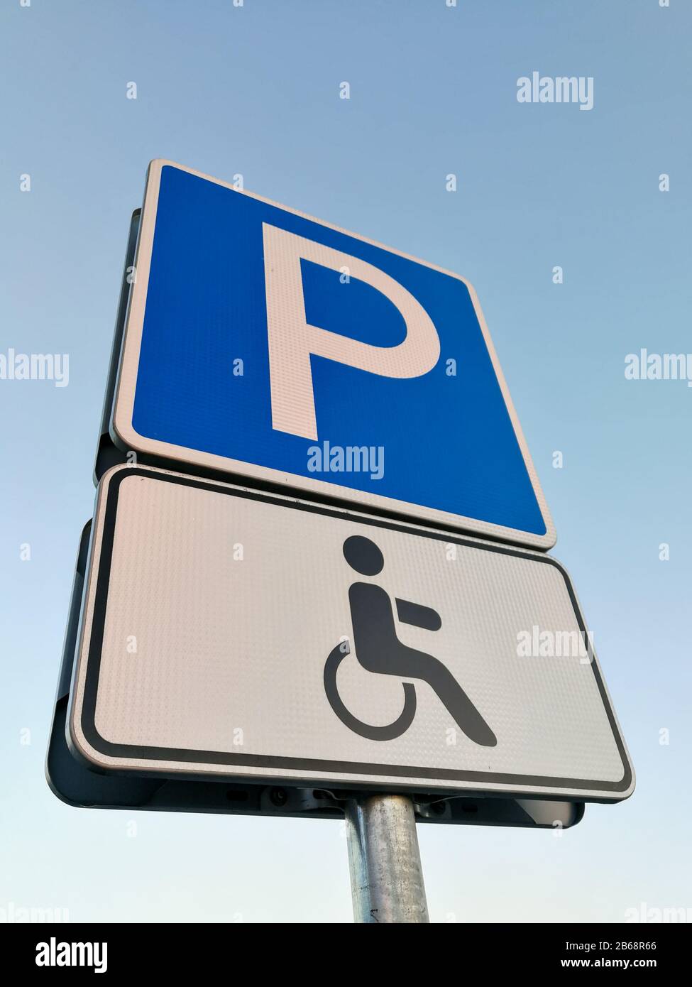 Persone disabili in Europa parcheggio segno di fronte al cielo blu Foto Stock