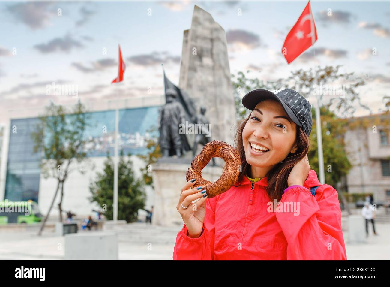 Felice donna che mangia tradizionale pane turco simit bagel a Istanbul, Turchia Foto Stock