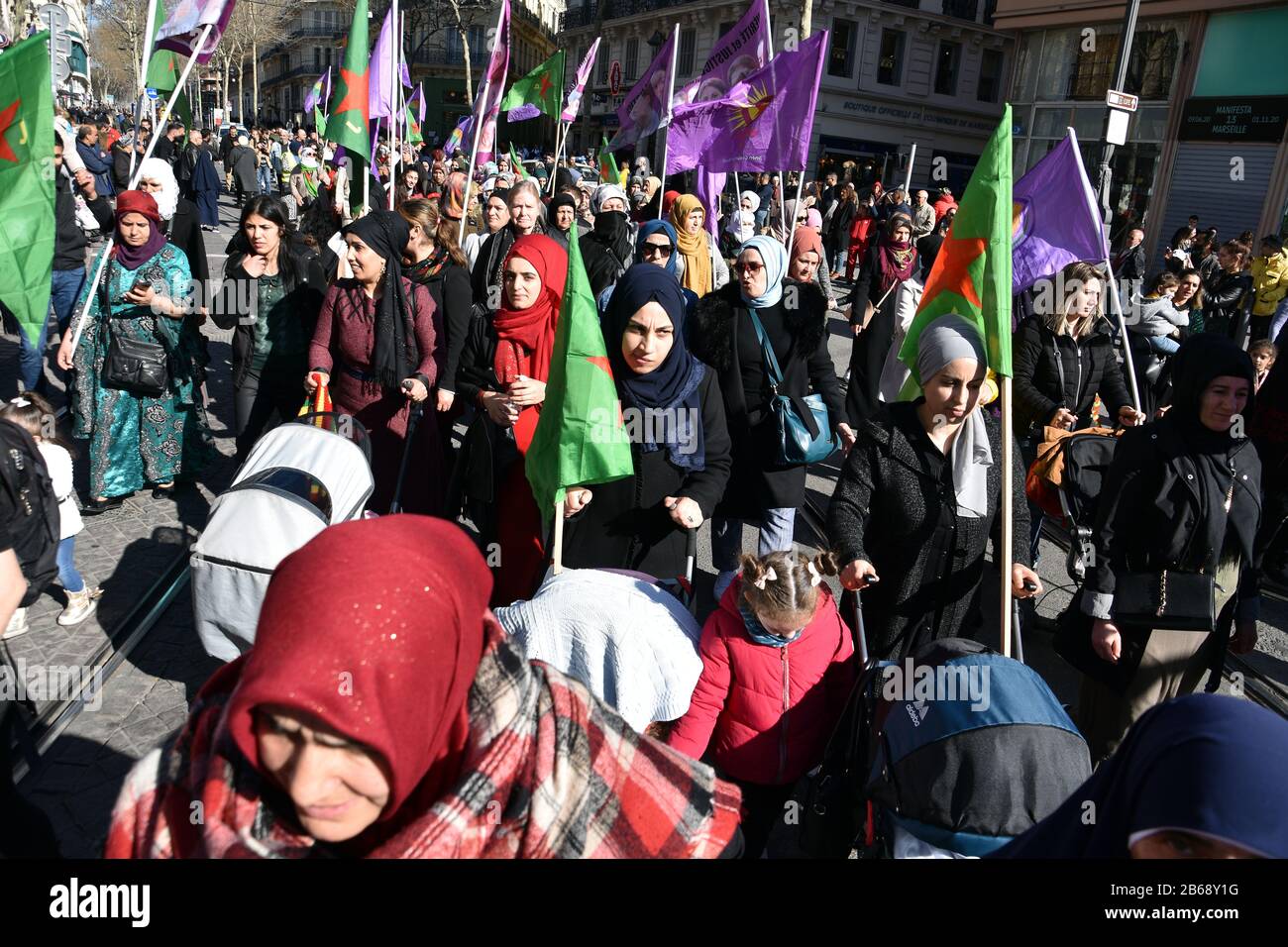 Le donne marciano tenendo bandiere durante la protesta.le donne curde di Marsiglia marciano per le strade in solidarietà con le donne del Kurdistan. Foto Stock