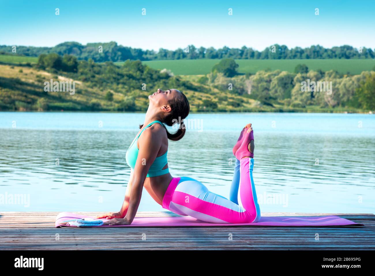 Bella ragazza pratica yoga sullo sfondo di una bella natura. Pilates. Concetto di stile di vita sano Foto Stock