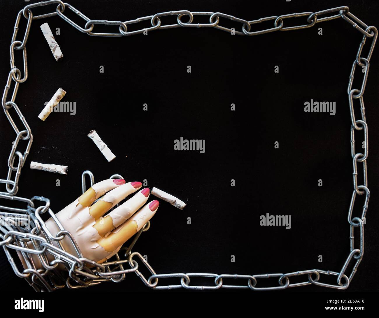 Concetto con manichino mano in catene raffiguranti la schiavitù del fumo, nicotina, dipendenza da sigarette. Foto Stock