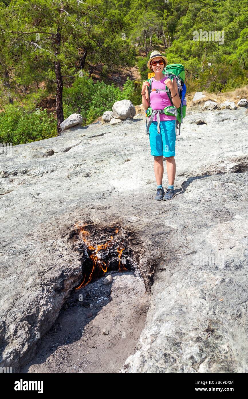 Donna escursionista turistico guardando Yanartas chimera fiamme nel parco nazionale Olympos in Turchia Foto Stock