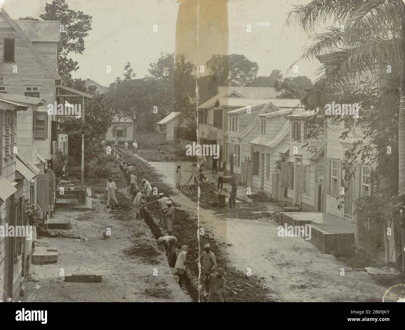 Costruzione di tubi per gas in lavori di scavo di Paramaribo per la costruzione di un gasdotto in Paramaribo. In una strada da parte dei lavoratori è una lunga slot gegreven. Produttore : fotografo: Anonymous location manufacturing: Paramaribo Dating: CA. 1903 - ca. 1940 Materiale: Carta fotografica Tecnica: Fotografia dimensioni: H 90 mm × W 120 mm Oggetto: Scavo (processo industriale) Quando: 1903 - 1940 Foto Stock