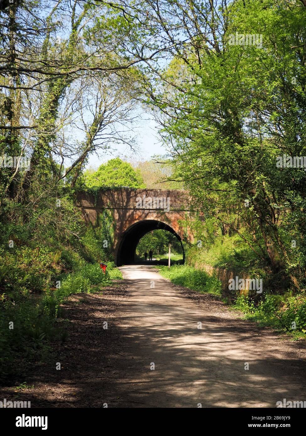 Vecchio tunnel ferroviario su un percorso ciclabile in primavera Foto Stock