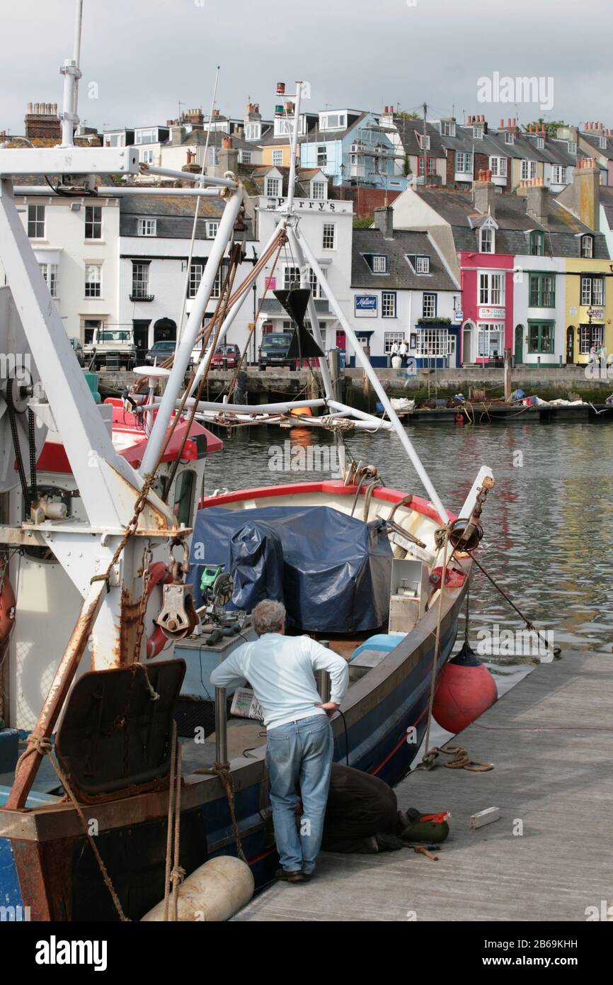Weymouth Quay: Trinity Road da Custom House Quay, con una barca da pesca in primo piano: Weymouth, Dorset, UK Foto Stock