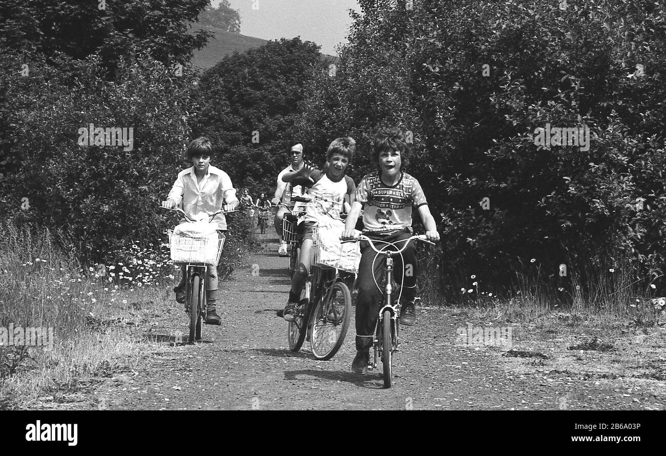 Anni '1970, storia, giovani che si divertono in bicicletta, fuori su un sentiero di ghiaia attraverso la campagna rurale, Inghilterra, Regno Unito. Foto Stock