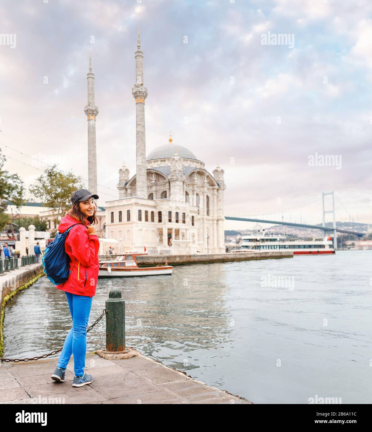 Una ragazza turistica cammina vicino alla grande vista a Istanbul, la moschea di Ortakoy Foto Stock