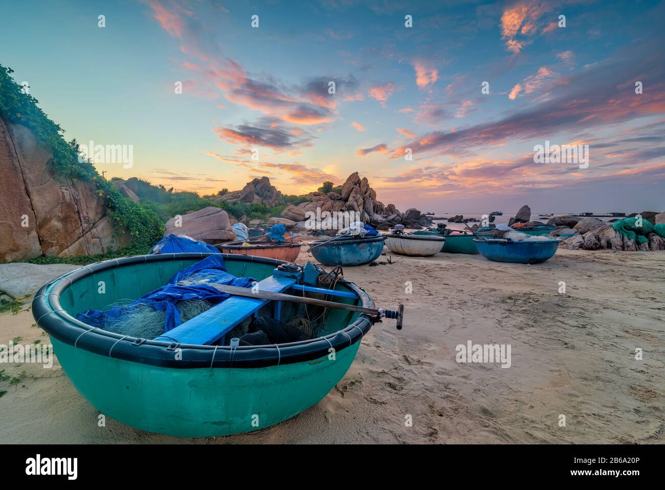 Barche tradizionali accanto al faro di Ke Ga, Binh Thuan, Vietnam. Foto Stock