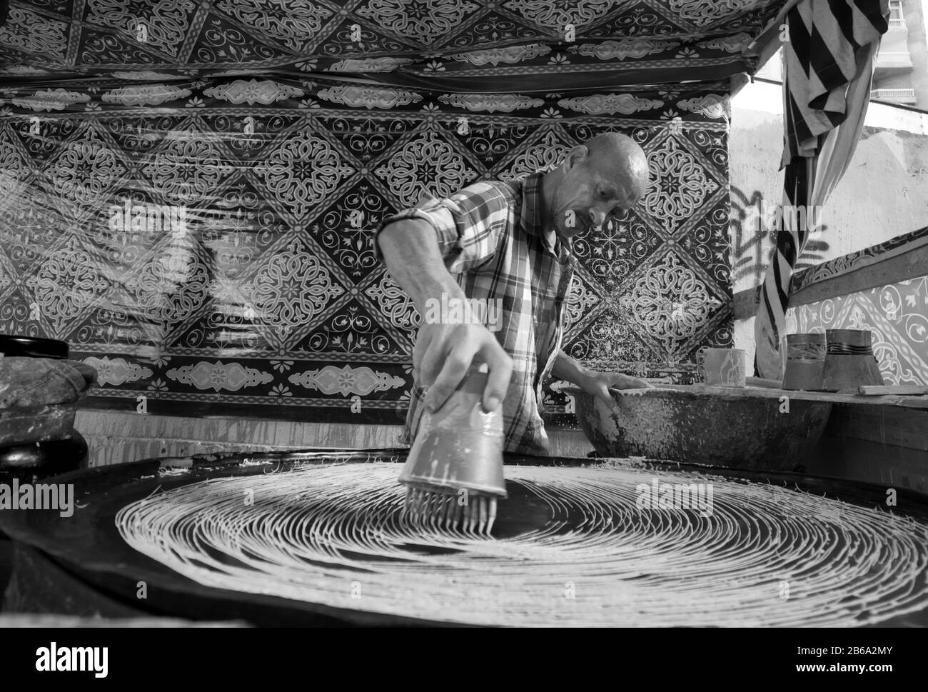 Alessandria, Egitto 6 febbraio 2019 il creatore e venditore di Konafa durante il mese santo del Ramadan che è un deserto arabo tradizionale Foto Stock