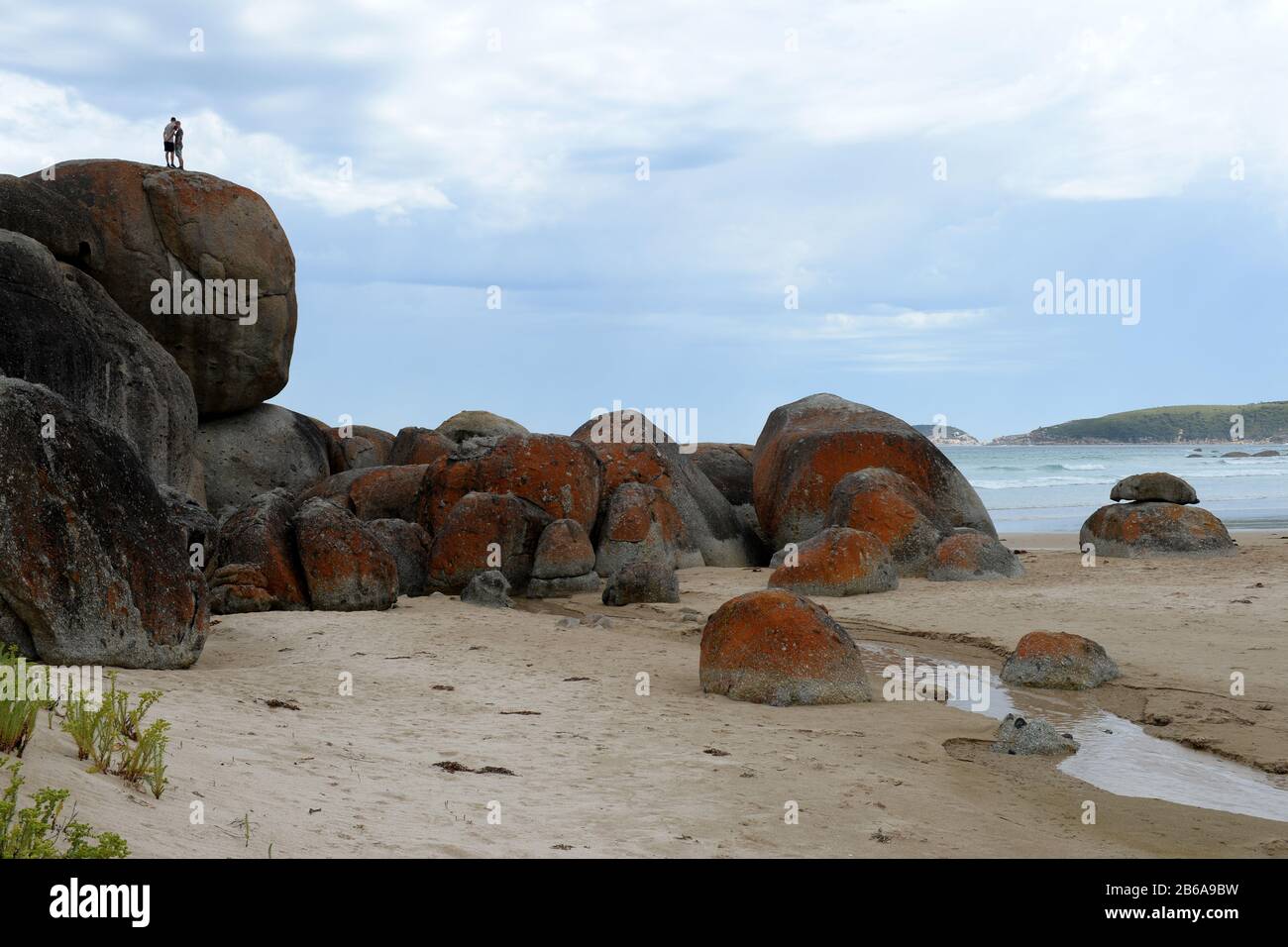 Due persone ammirano la vista dai massicci massi di granito che adornano la costa come sculture naturali a Wilsons Prom, Victoria, Australia Foto Stock