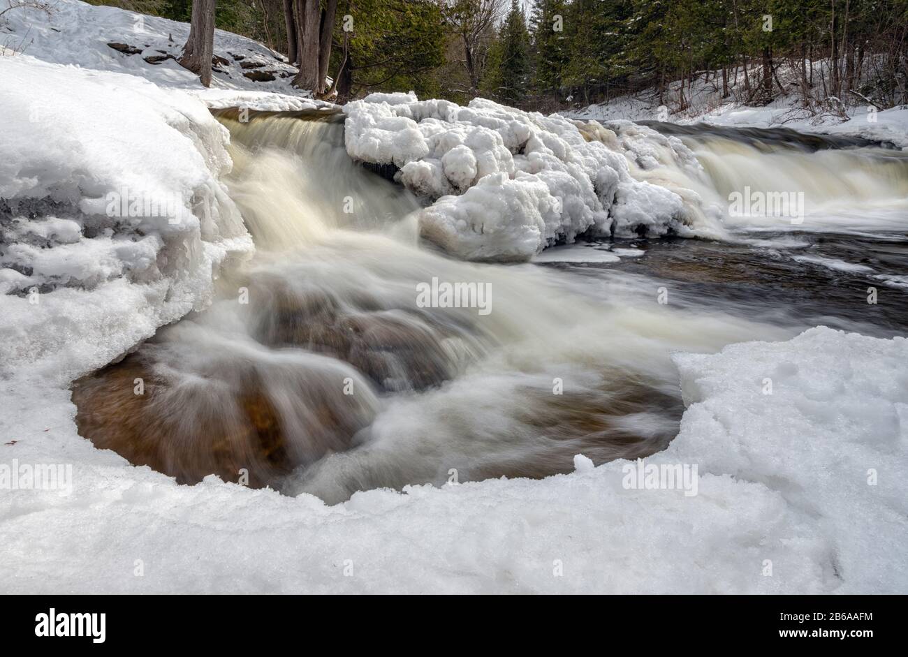 Le cascate di Ocqueoc attraversano il ghiaccio e la neve nei pressi di Rogers City, nel nord Del Michigan Inferiore, durante un inverno freddo Foto Stock