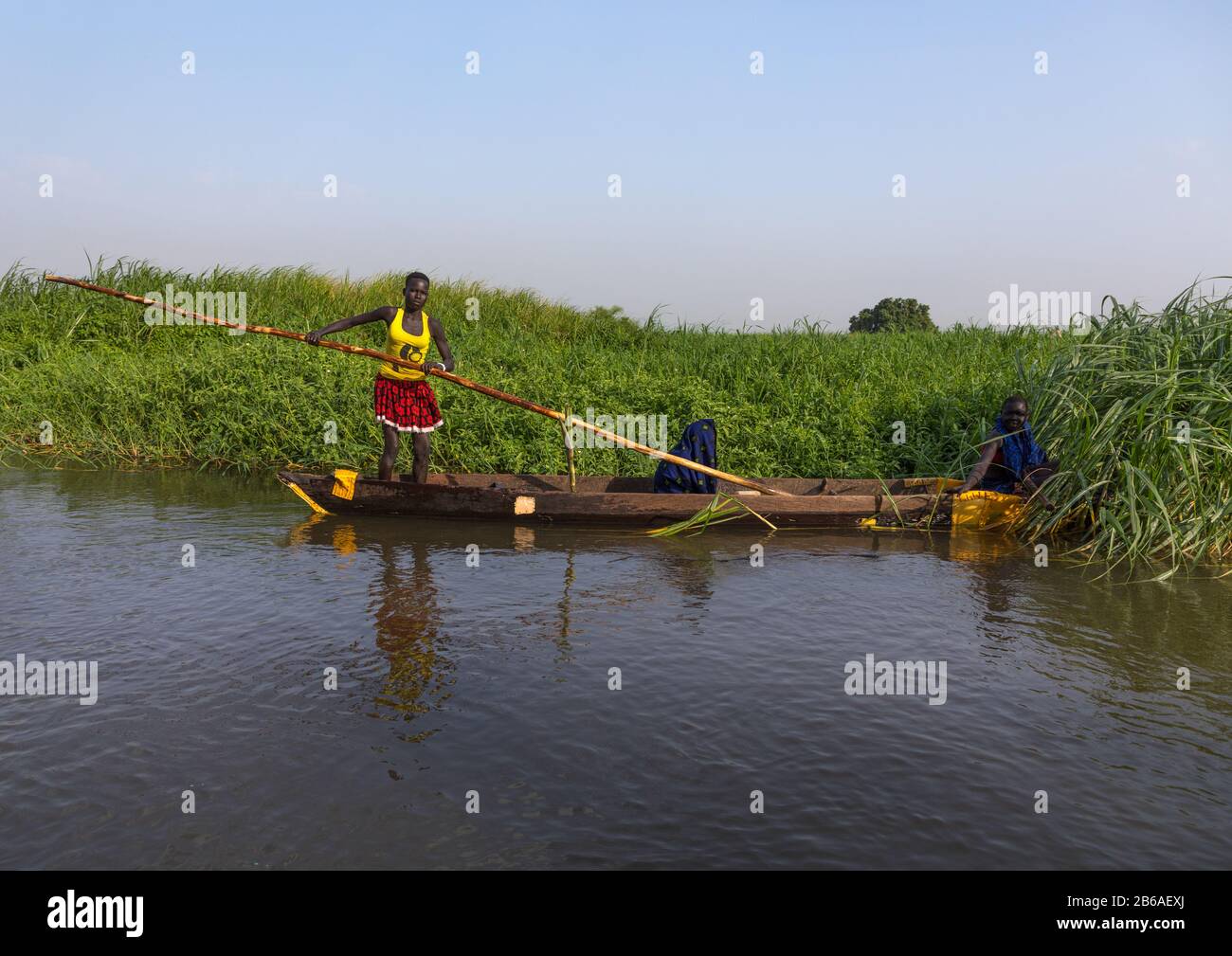 Mundari tribù donne canottaggio in una barca sul fiume Nilo, Equatoria centrale, Terekeka, Sud Sudan Foto Stock