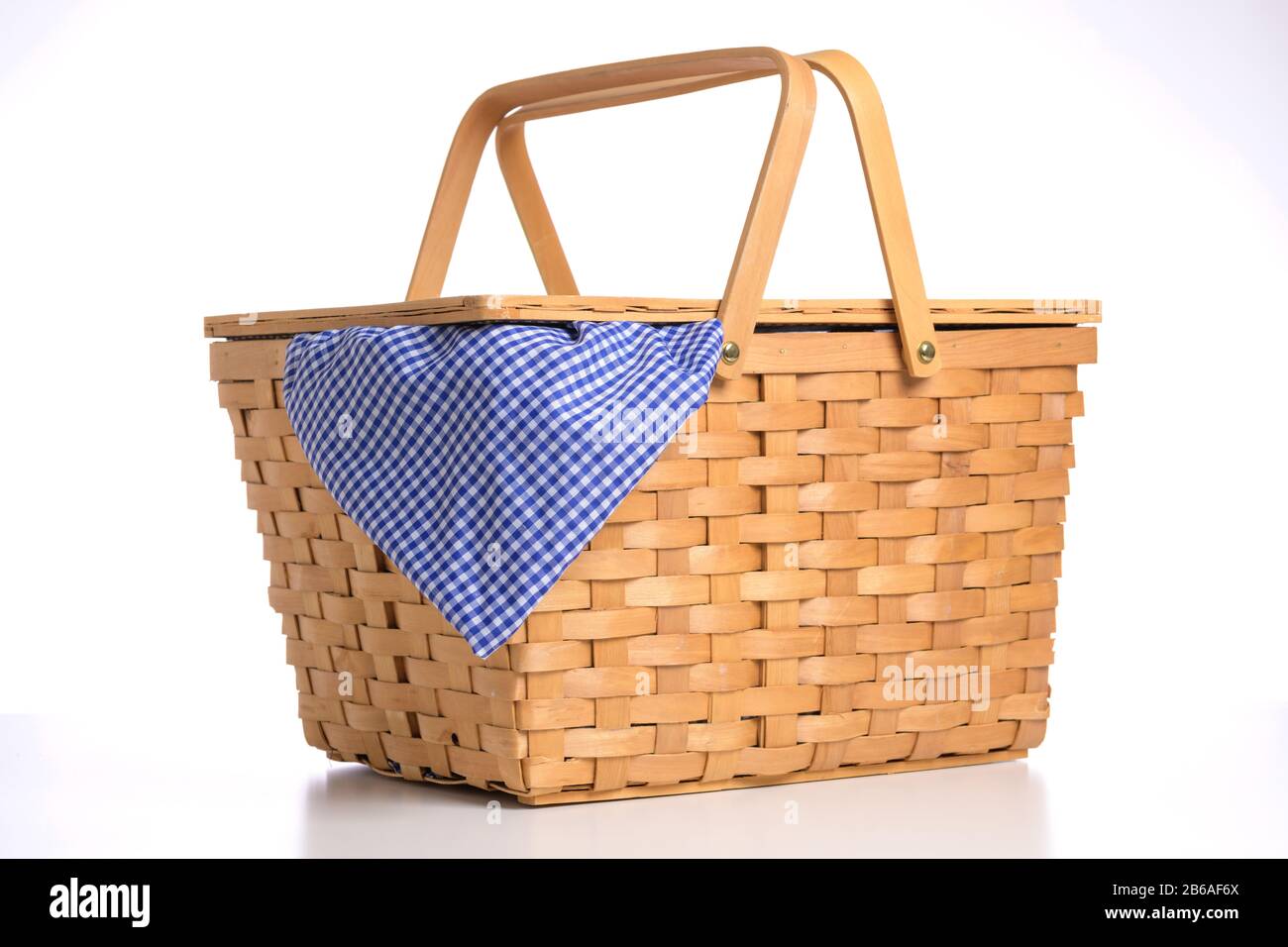 Cestino picnic in vimini su sfondo bianco con tovaglia blu di gingham Foto Stock