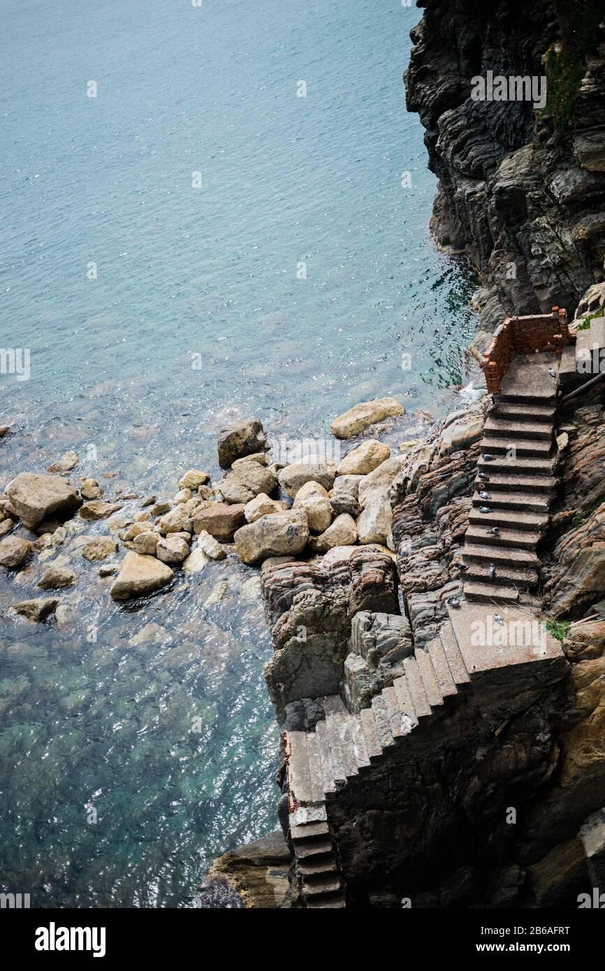 Scale che conducono all'entrata del mare su una scogliera rocciosa Foto Stock