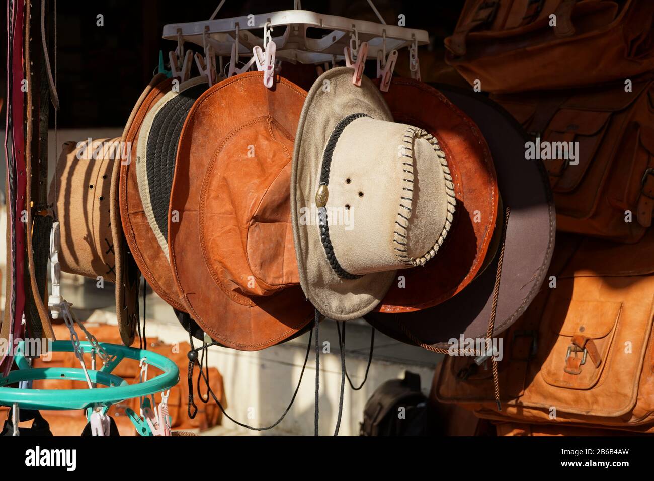 Cowboy Natale. American West cappelli tradizionali in pelle pura esposti all'aperto in vendita alla luce del sole. Sono appesi uno accanto all'altro. Foto Stock