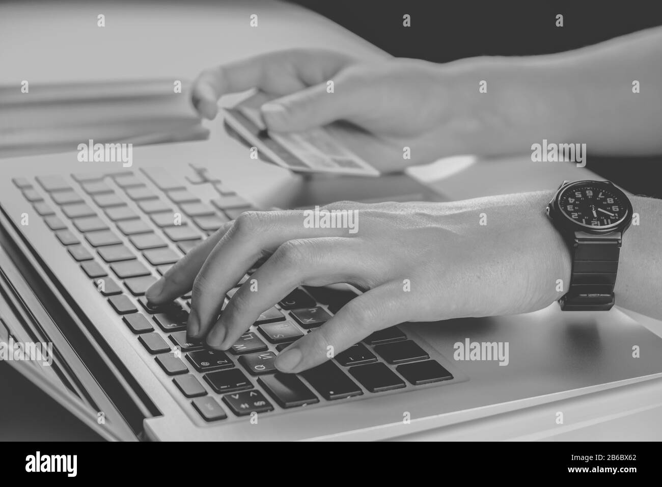Utilizzo della carta di credito per il pagamento online, in bianco e nero a chiave bassa. Persona che compila le informazioni del conto bancario mentre acquista qualcosa in Internet Foto Stock