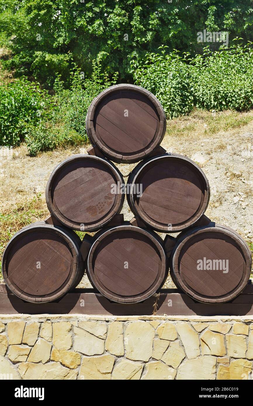 Sei botti di vino, costituite da una piramide verticale su un piedistallo di pietra. La vinificazione Foto Stock