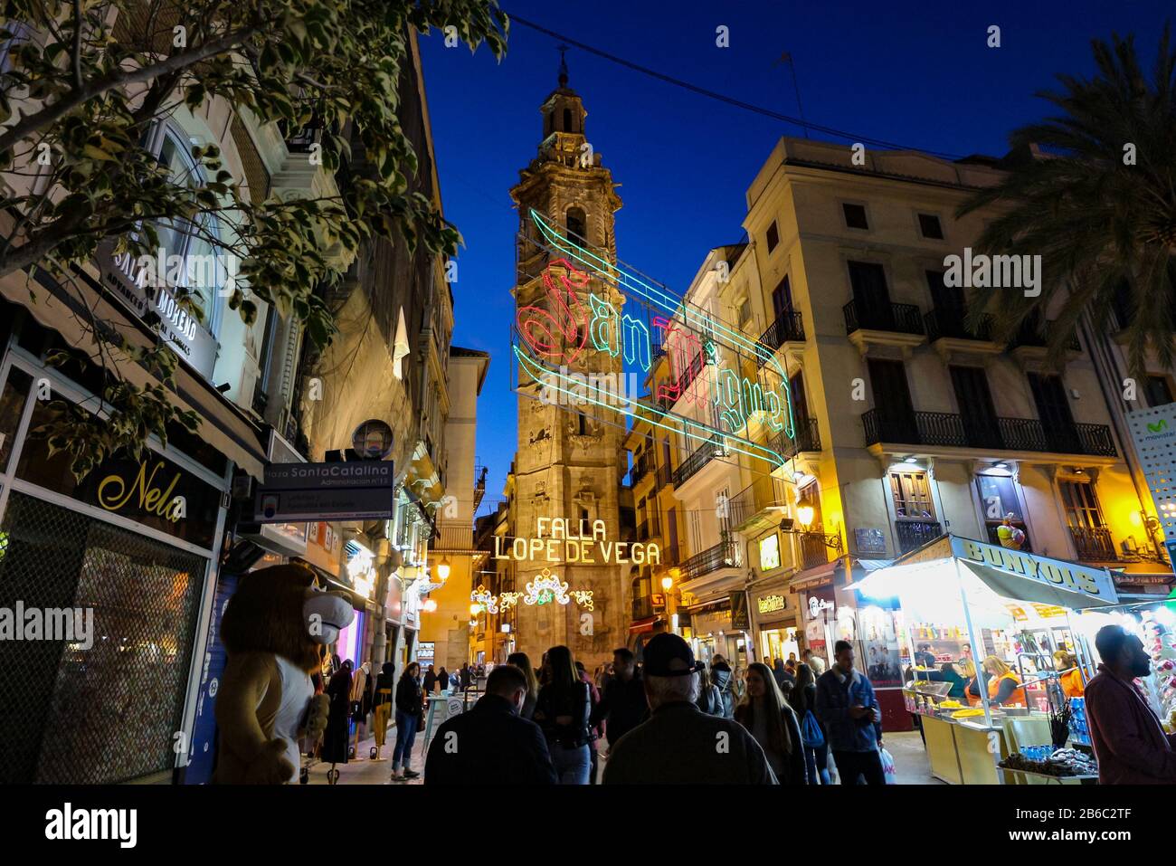 Strada illuminata per il festival Fallas 2020 che è stato annullato per prevenire la diffusione del coronavirus, con la chiesa di Santa Catalina sullo sfondo. Foto Stock