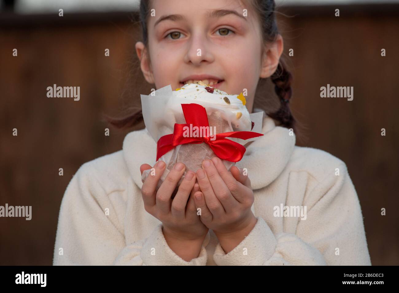 Una bambina felice che guarda una torta orientale. Concetto di Pasqua ...