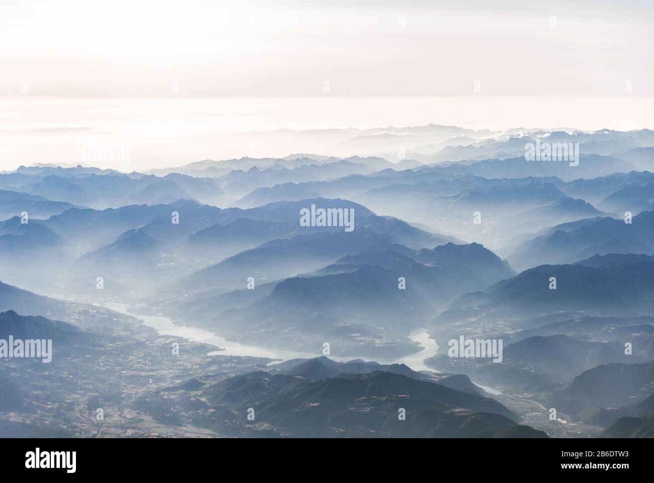 Paesaggio vista aerea delle Alpi blu montagne con nuvole, fiumi e nebbia. Foto Stock