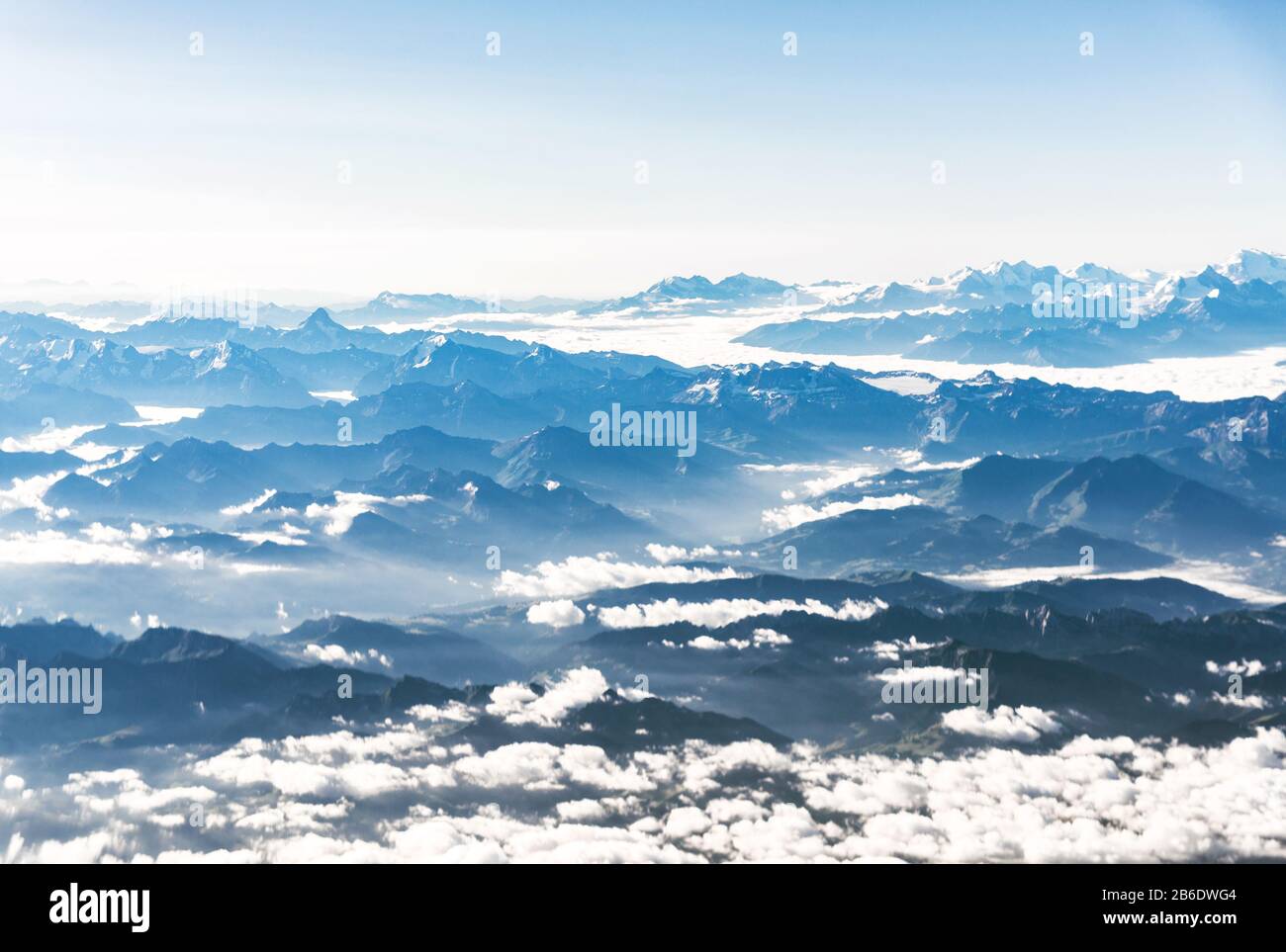 Paesaggio vista aerea delle Alpi blu montagne con nuvole sopra la Svizzera. Foto Stock