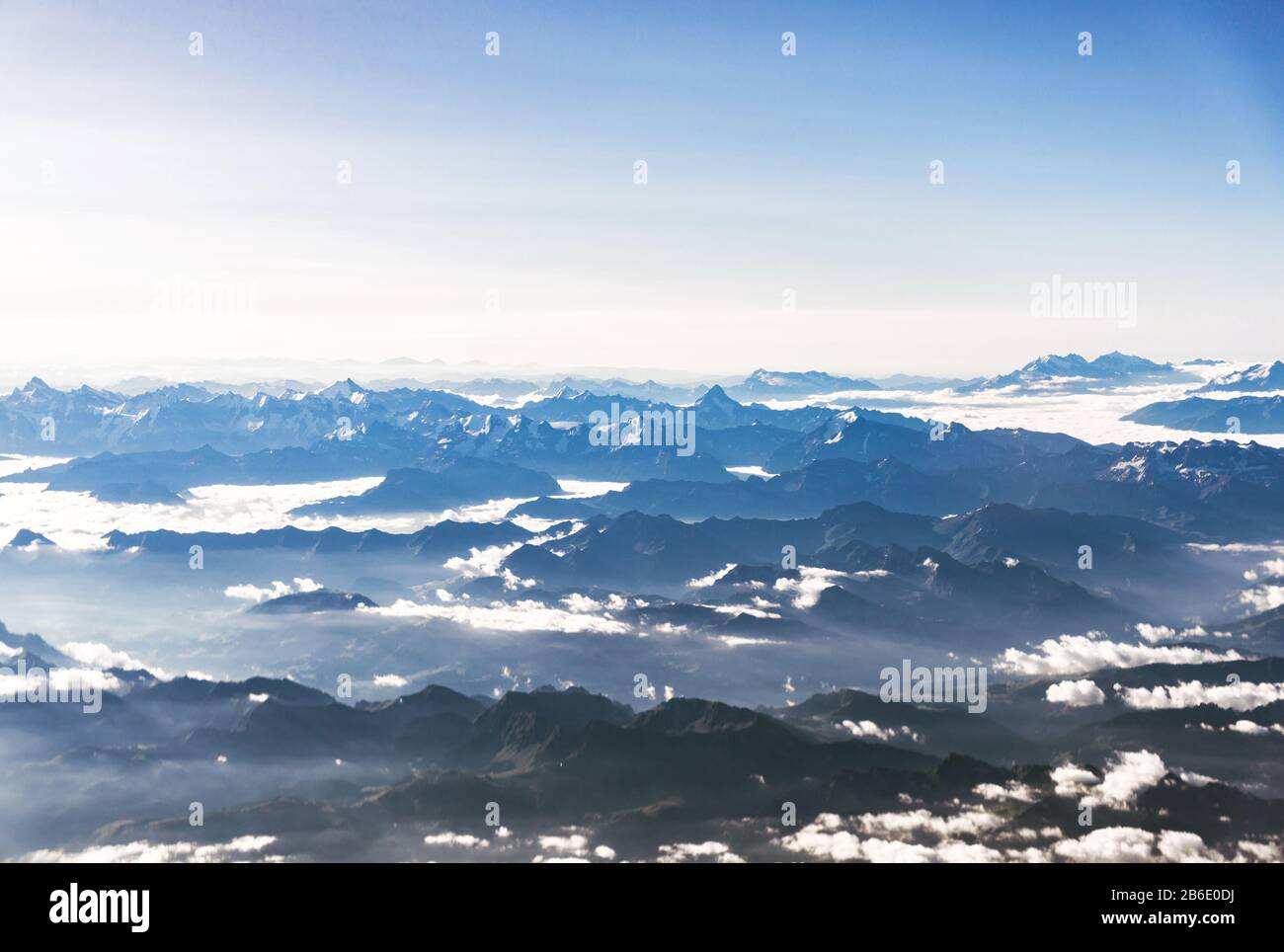 Paesaggio vista aerea delle Alpi blu montagne con nuvole sopra la Svizzera. Foto Stock