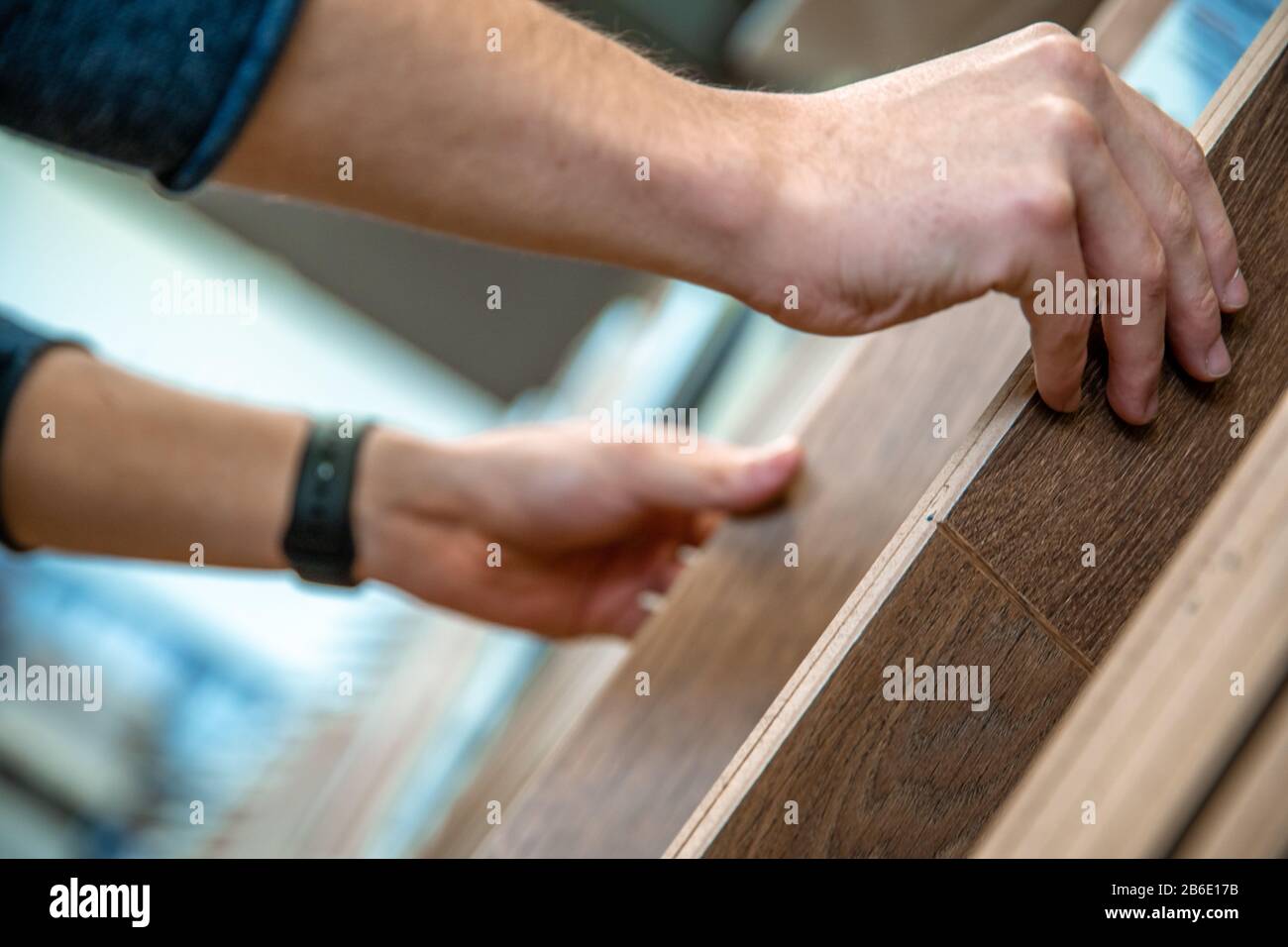 Il maschio sceglie il pavimento in legno del campione nel commercio specializzato Foto Stock