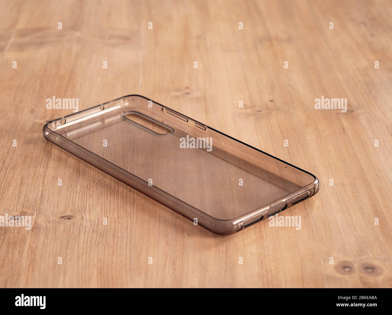 Custodia mobile morbida trasparente in un tavolo in legno chiaro Foto Stock