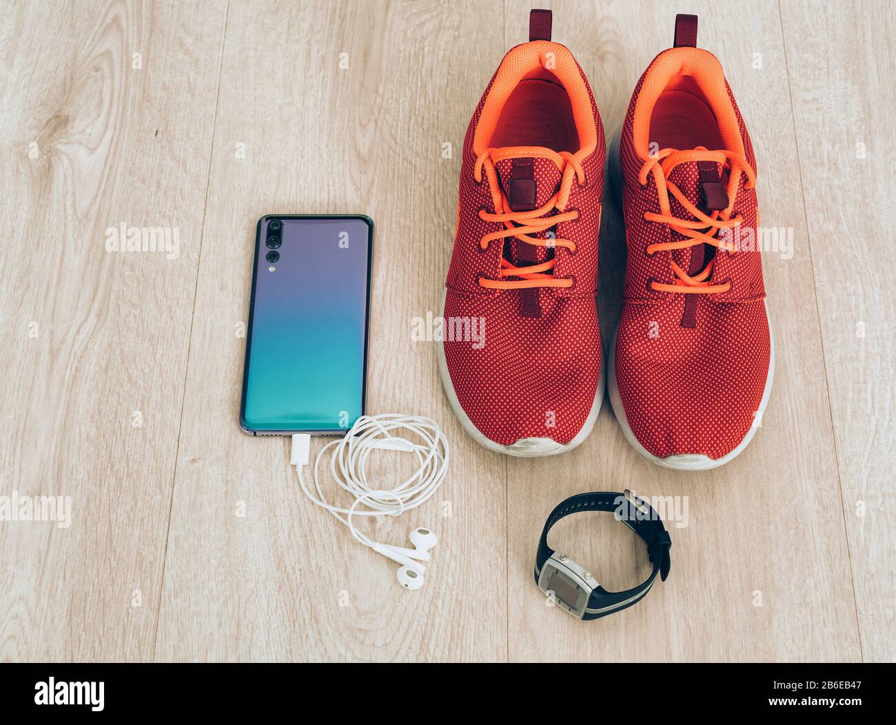 Sneaker fresche da running con smartphone, auricolari e orologio sportivo fitbit. Pronto per la formazione, vita sana Foto Stock