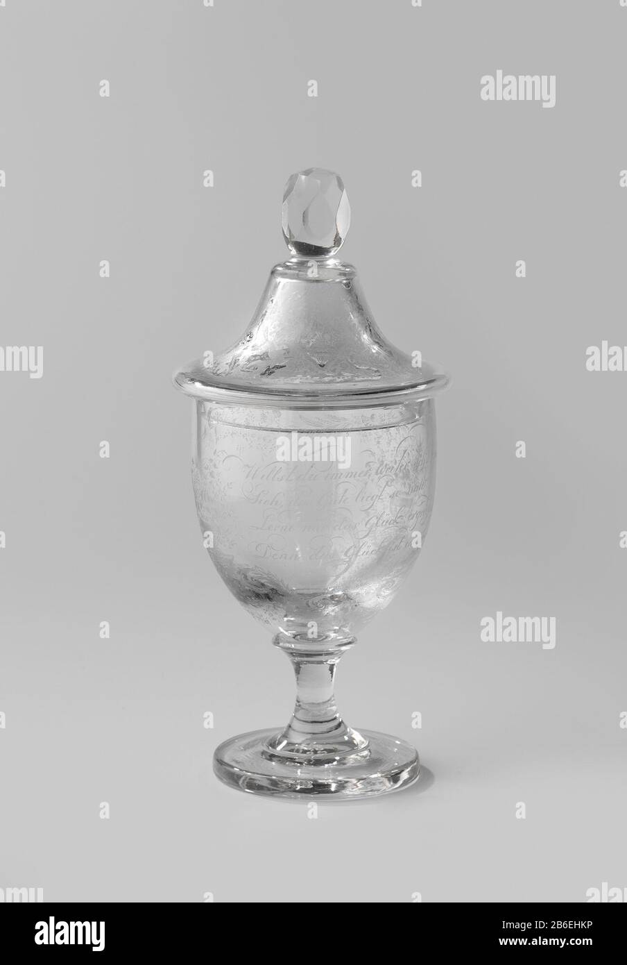 Calice con una poesia di Goethe Platte voet. Convexe stam, gebogen kelk. Klokvormig deksel met een gefacetteerde knop. Tussen twee met bloemen en vruchten gevulde vazen een gedicht van Goethe: Willst du immer weiter schweissen?/ Sieh, das Gute liegt so nah,/ Lerne nur das Glück ergreifen,/ Denn das Glück ist immer da/ Göthe/ Boven linder en der het gedicht bloem- en en. Onder de linker vaas de signatuur en het jaartal DHdC. 1860. Produttore : glasblazer: Anoniemglasgraveur: Daniël H. de CastroPlats fabbricante: Glasblazer: Frankrijkglasgraveur: Amsterdam datazione: 1860 Fisico Foto Stock