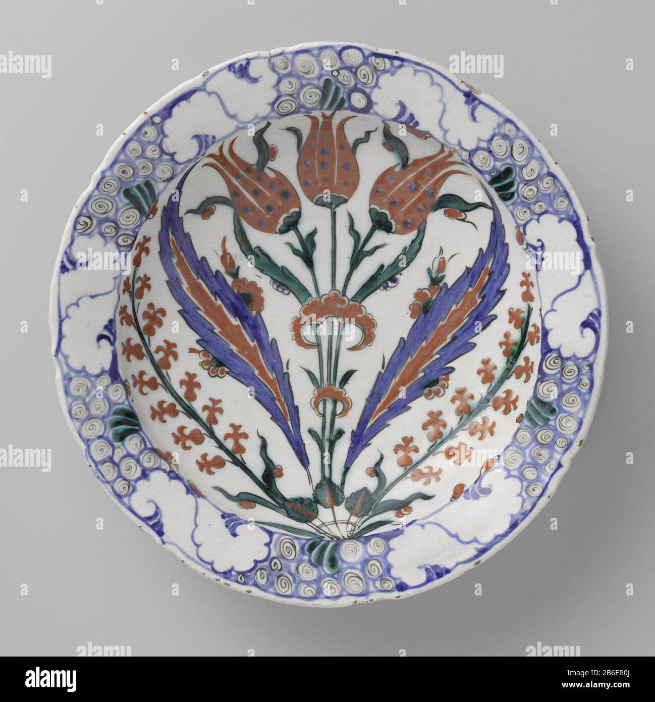 Piatto con motivi floreali segno con una pianta fiorita Kwarts-fritgoed ha incontrato lood bord gedecoreerd ha incontrato bloeiende planten (tulpen), bloemen in blauw, rood, groen, zwart op wit onder een trasparente lood-alkali-tinglazuur. Produttore : pottenbakker: AnoniemPlaats fabbricante: Iznik Dating: CA. 1570 - ca. 1590School / stijl: Osmanen Physical kenmerken: Aardewerk (kwarts-fritgoed) Met glazuur Materiale: Aardewerk kwarts-fritgoed glazuur Techniek: Draaiend bwerken / bakken / slibtechniek / schilderen / glazuren dimensioni: H 6,7 cm. E: D 30,5 cm. Foto Stock