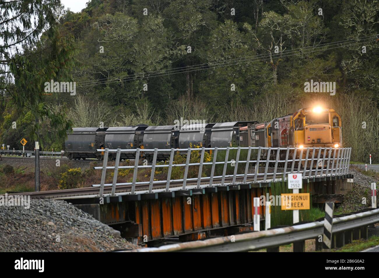 NGAHERE, NUOVA ZELANDA, 2 SETTEMBRE 2019: Un piccolo treno di carbone gira l'angolo per attraversare il ponte a Ongionui Creek vicino Ngahere sulla costa occidentale Foto Stock