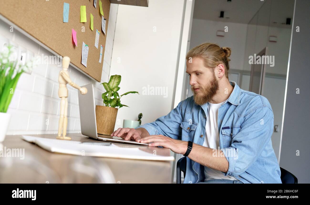 Giovane uomo felice lavoro sul tipo di progetto e-mail laptop home Office concetto copyspace. Foto Stock