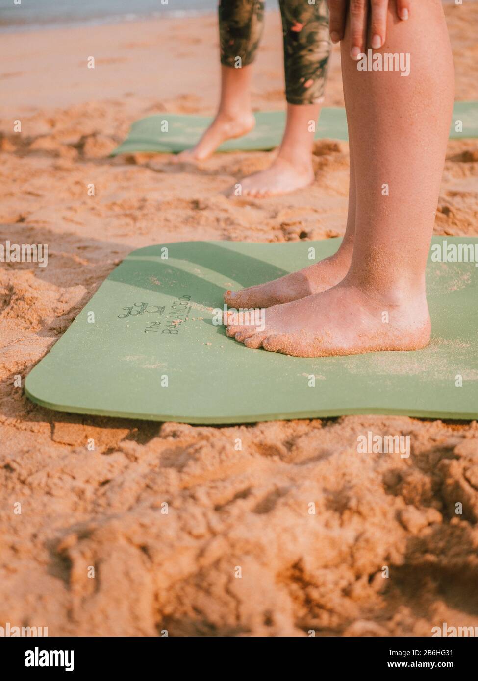 Una donna che conduce una lezione privata di yoga sulla spiaggia In Australia Occidentale Foto Stock