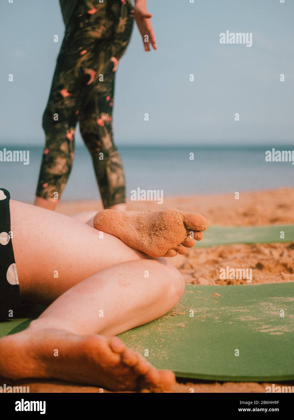 Una donna che conduce una lezione privata di yoga sulla spiaggia In Australia Occidentale Foto Stock