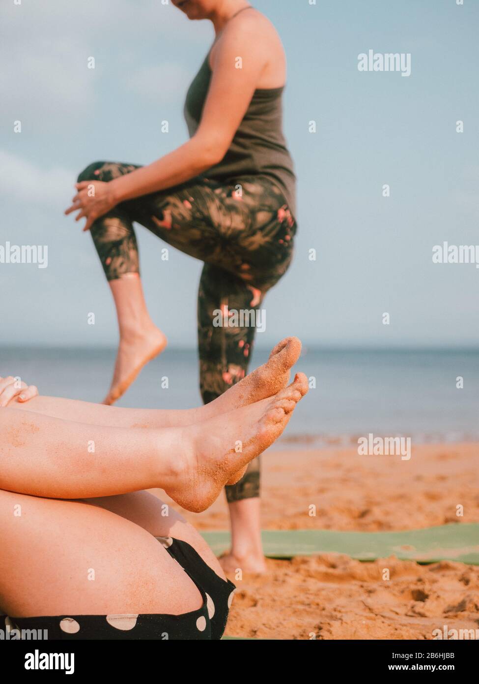 Una donna che conduce una lezione privata di yoga sulla spiaggia In Australia Occidentale Foto Stock
