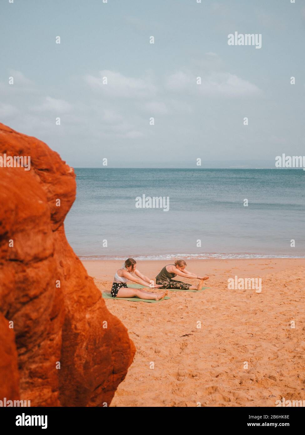 Una donna che conduce una lezione privata di yoga sulla spiaggia In Australia Occidentale Foto Stock