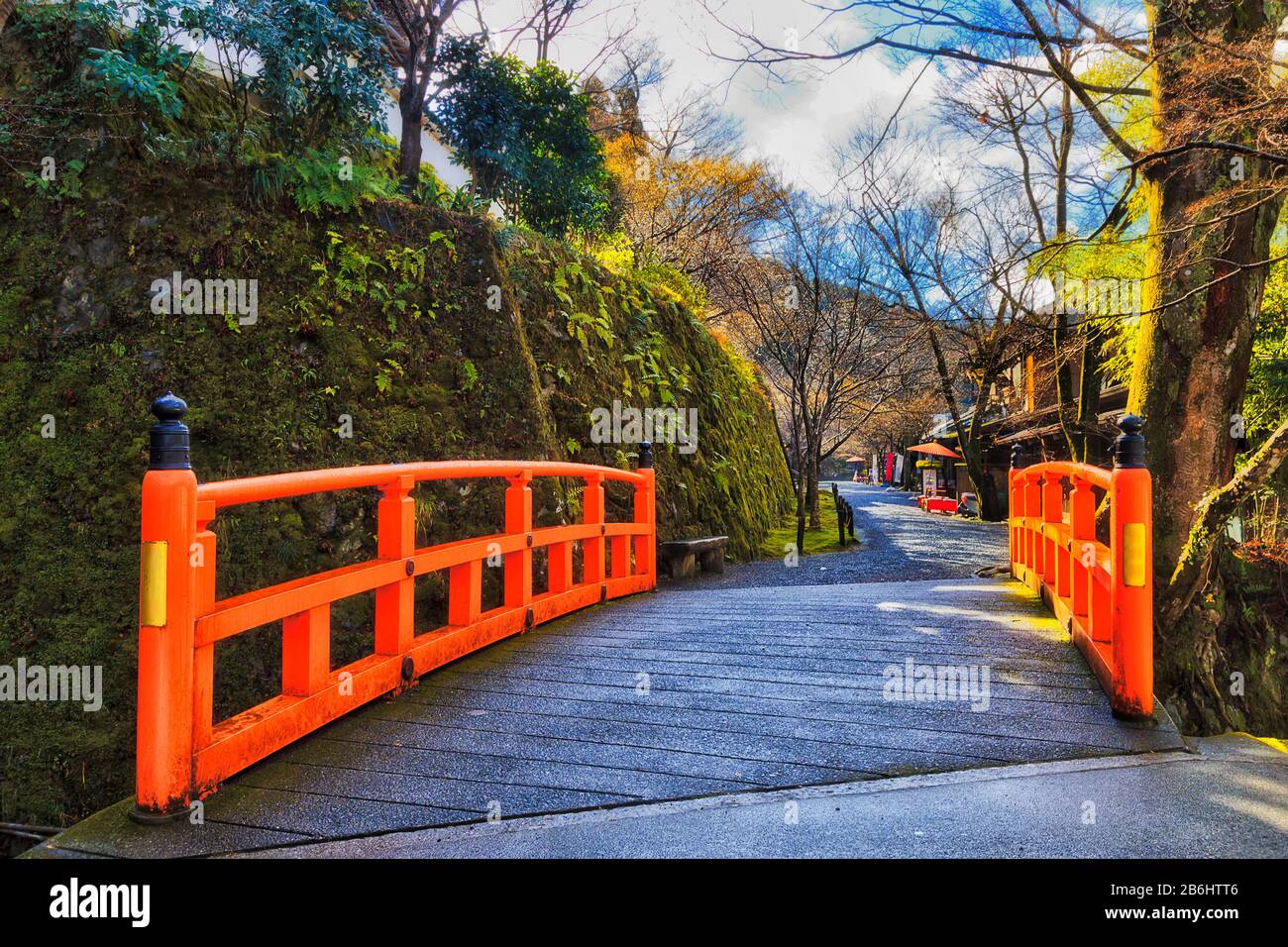 Ponte rosso attraverso il torrente di montagna locale in piccolo villaggio remoto Ohara vicino a Kyoto in Giappone. Famoso per i suoi templi buddisti storici e l'agricoltura wi Foto Stock