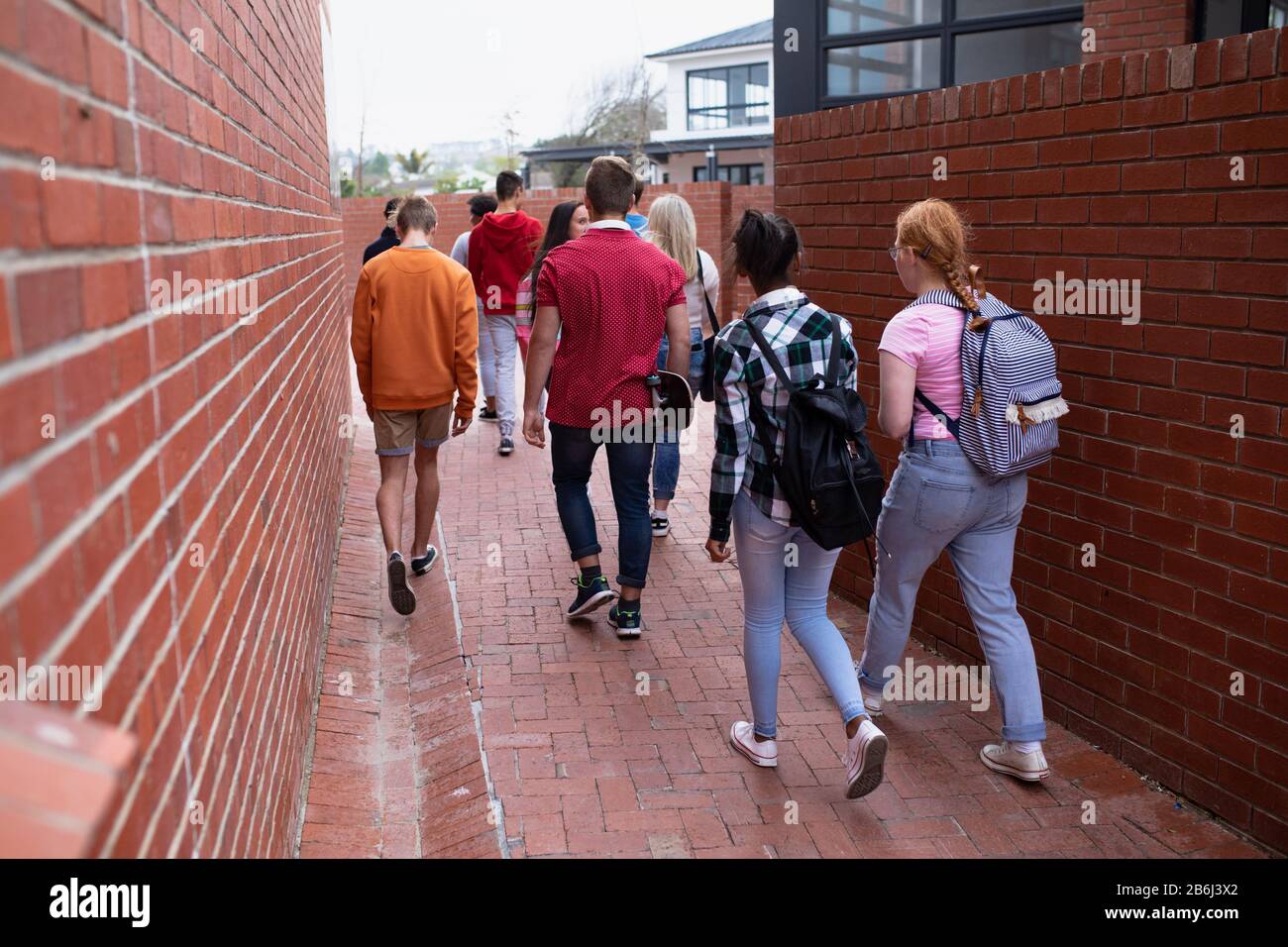 Vista posteriore degli amici che camminano insieme all'esterno Foto Stock