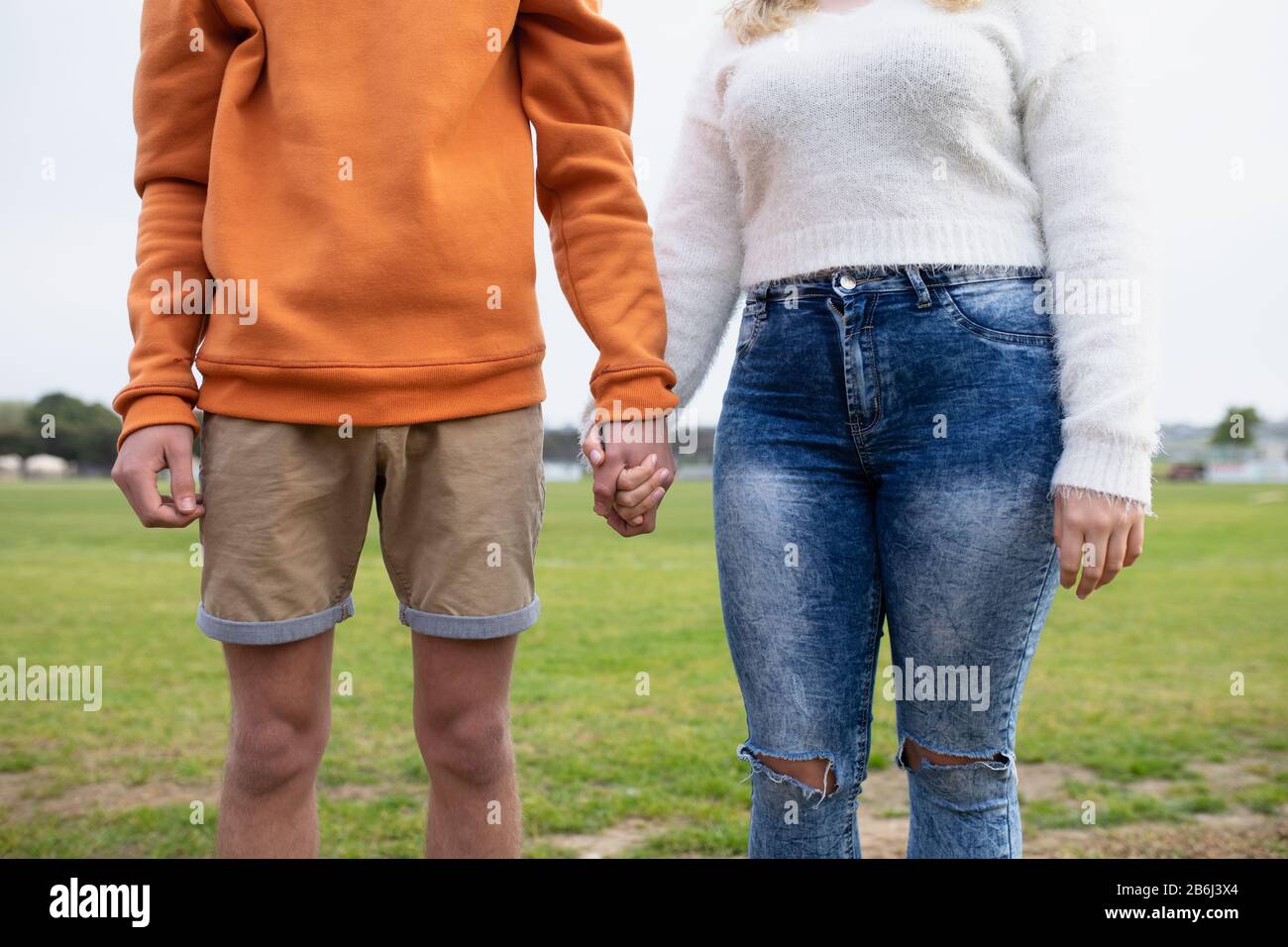 Vista frontale della sezione centrale della coppia che tiene le mani all'esterno Foto Stock