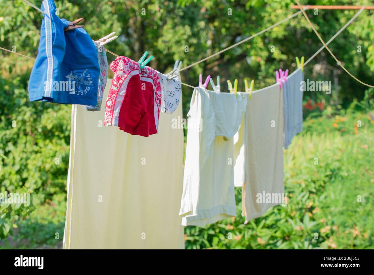 Asciugatura pulita della biancheria in linea all'esterno dello sfondo verde Foto Stock