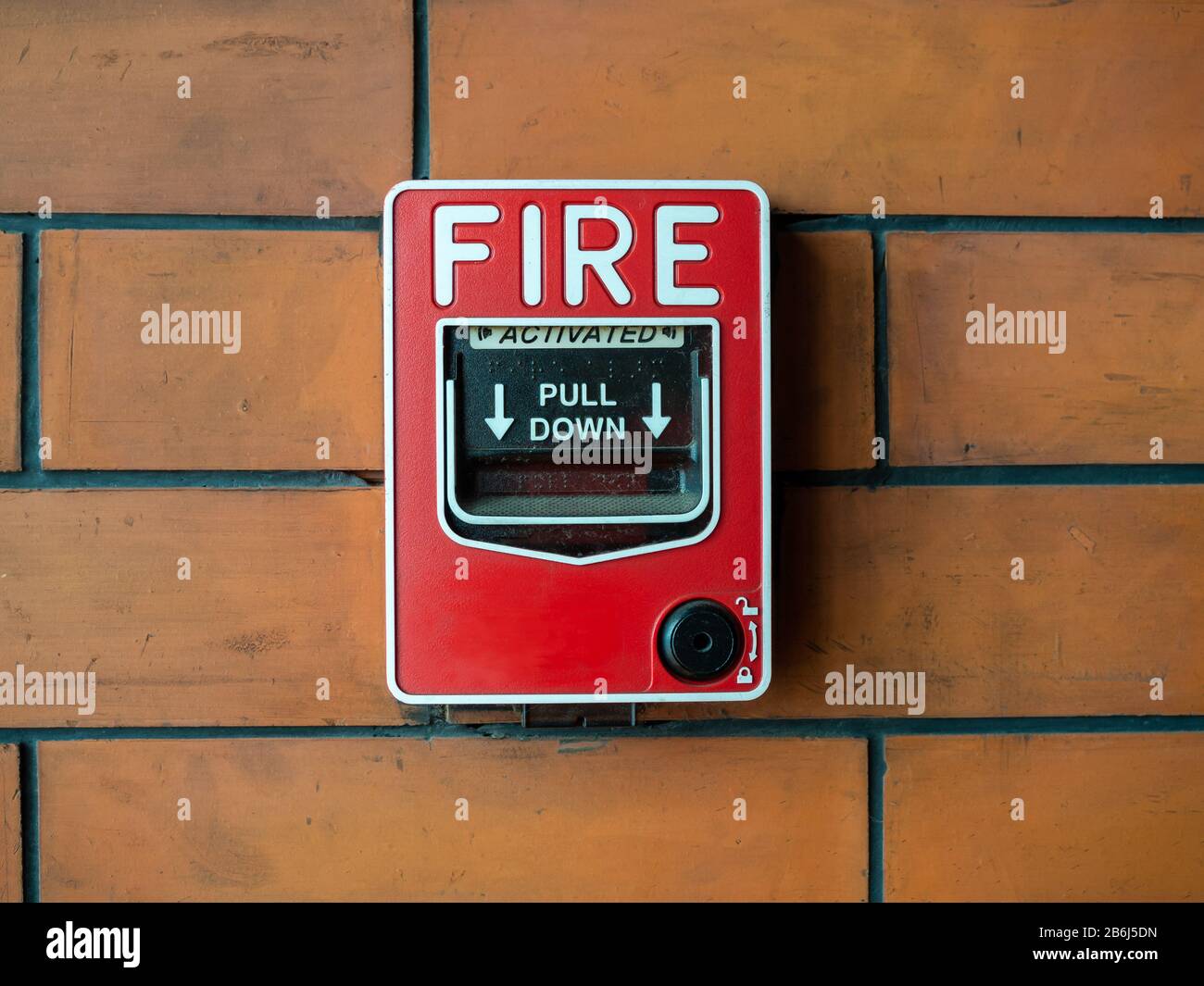 Sistema di sicurezza con allarme antincendio manuale rosso. Postazione di tiro ravvicinata o call point, attivazione manuale di allarme antincendio su sfondo a parete in mattoni. Foto Stock