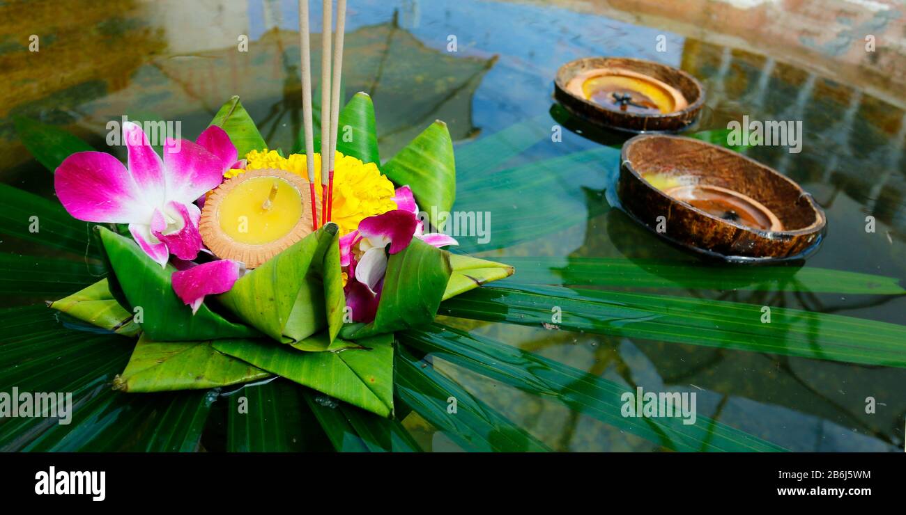 krathong, cesto galleggiante artigianale da banana foglia, decorato con fiori e bastoni di incenso, candela, luce e galleggiare sull'acqua per celebrare il festival Foto Stock