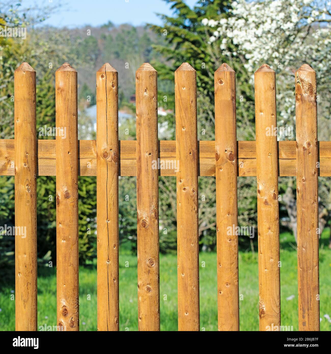 Recinto campo fatto di doghe di legno di fronte ad un giardino Foto Stock
