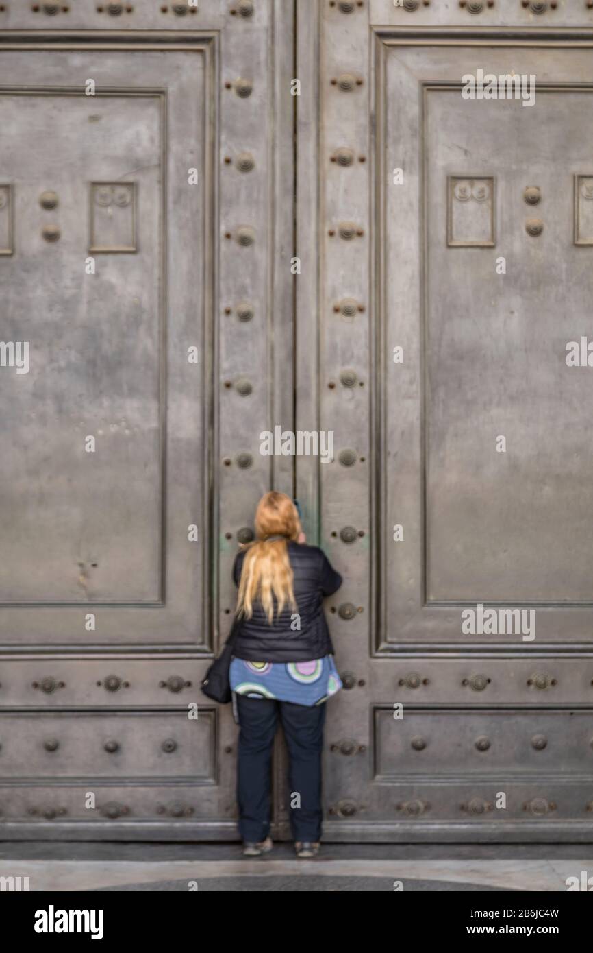 I turisti cercano di vedere l'interno del Pantheon, le cui famose porte sono state chiuse al pubblico come parte delle precauzioni Coronavirus a Roma, Italia Foto Stock