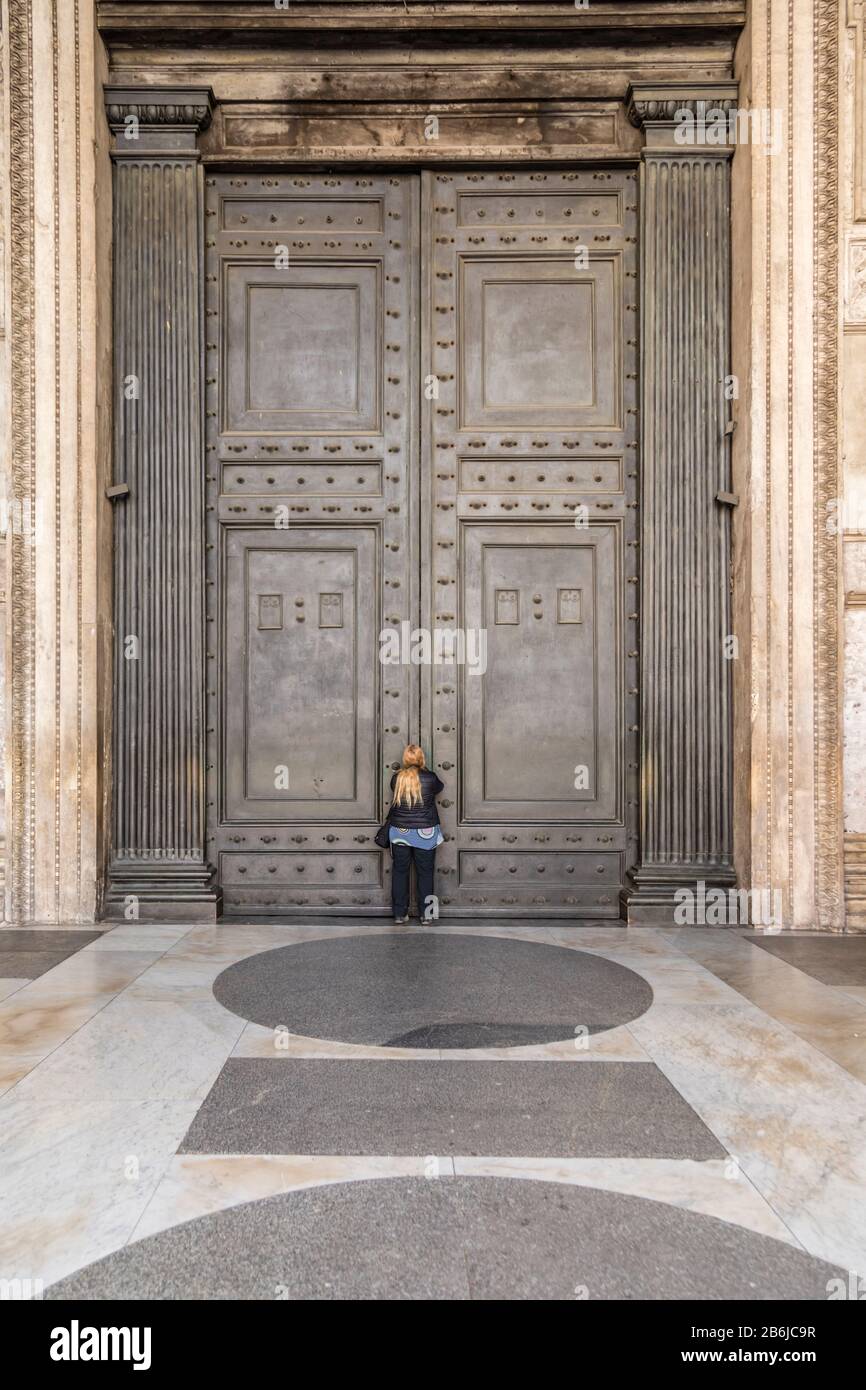 I turisti cercano di vedere l'interno del Pantheon, le cui famose porte sono state chiuse al pubblico come parte delle precauzioni Coronavirus a Roma, Italia Foto Stock