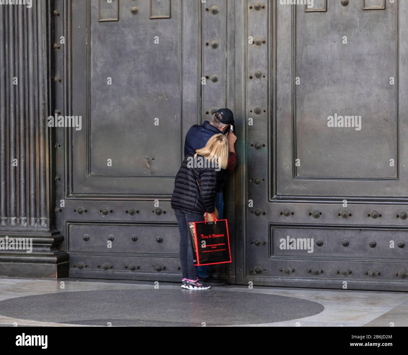 I turisti cercano di vedere l'interno del Pantheon, le cui famose porte sono state chiuse al pubblico come parte delle precauzioni Coronavirus a Roma, Italia Foto Stock