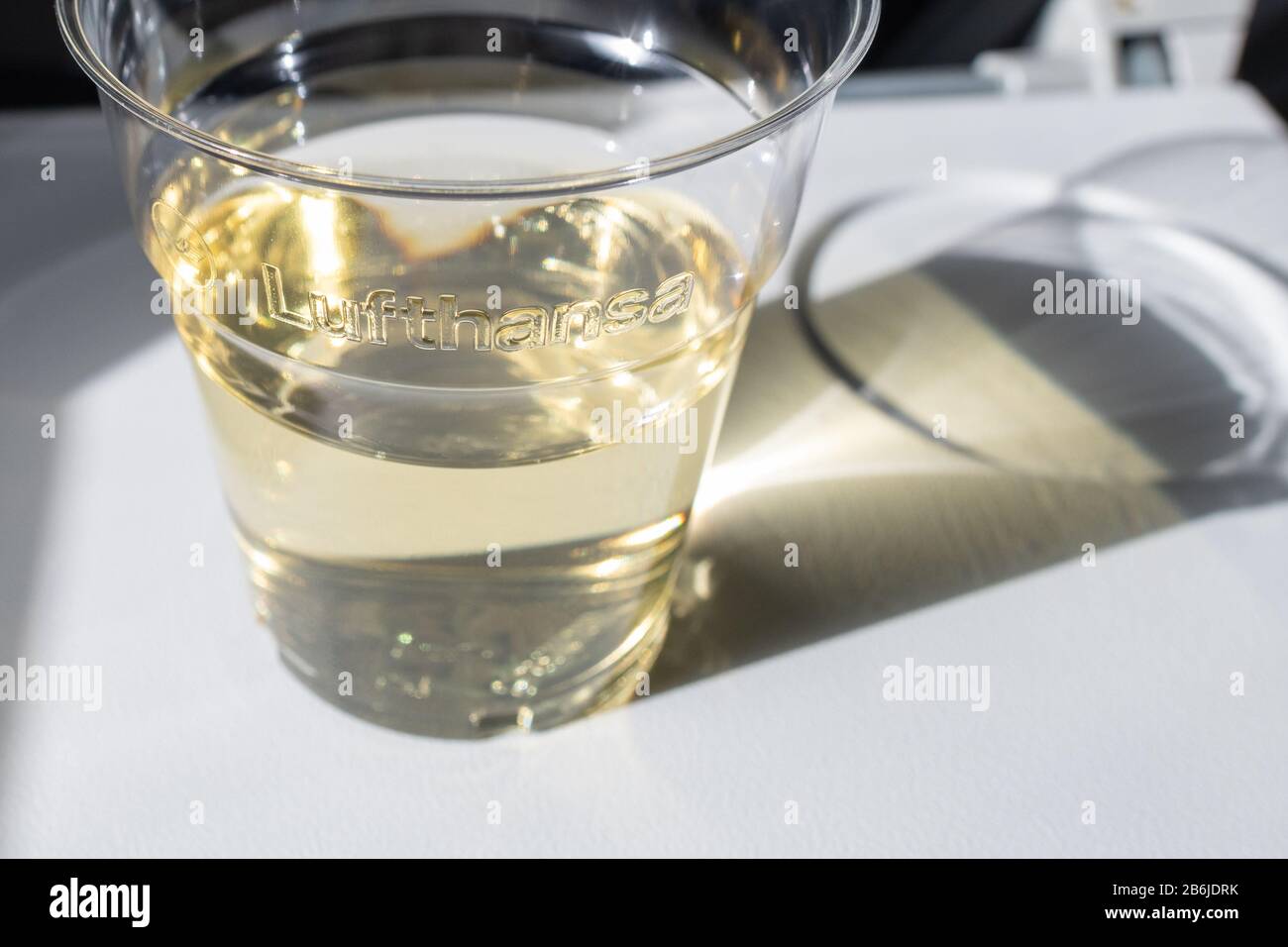 Vino bianco in tazza di plastica sul volo Lufthansa Foto Stock