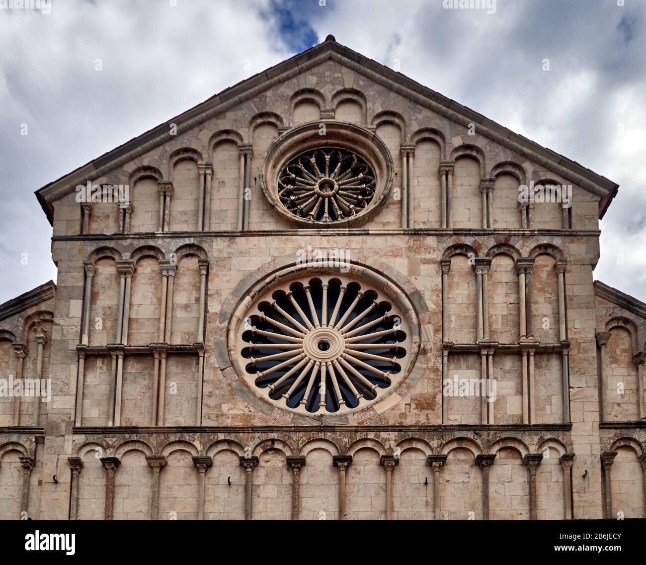 Zadar, provincia della Dalmazia, Croazia, la façade principale della Cattedrale si trova sulla piccola piazza Trg Svete Stošije. La cattedrale è dedicata a Sant'Anastasia e al suo interno sono conservate le reliquie. Fu fondata dai Bizantini nel IX secolo ma ricostruita tra il XII e il XIV secolo. Nella sua architettura si mescolano elementi romanici e gotici come si può vedere nelle due rosette che decorano la sua facciata, romanica con il diametro più grande e gotica il più piccolo. Foto Stock