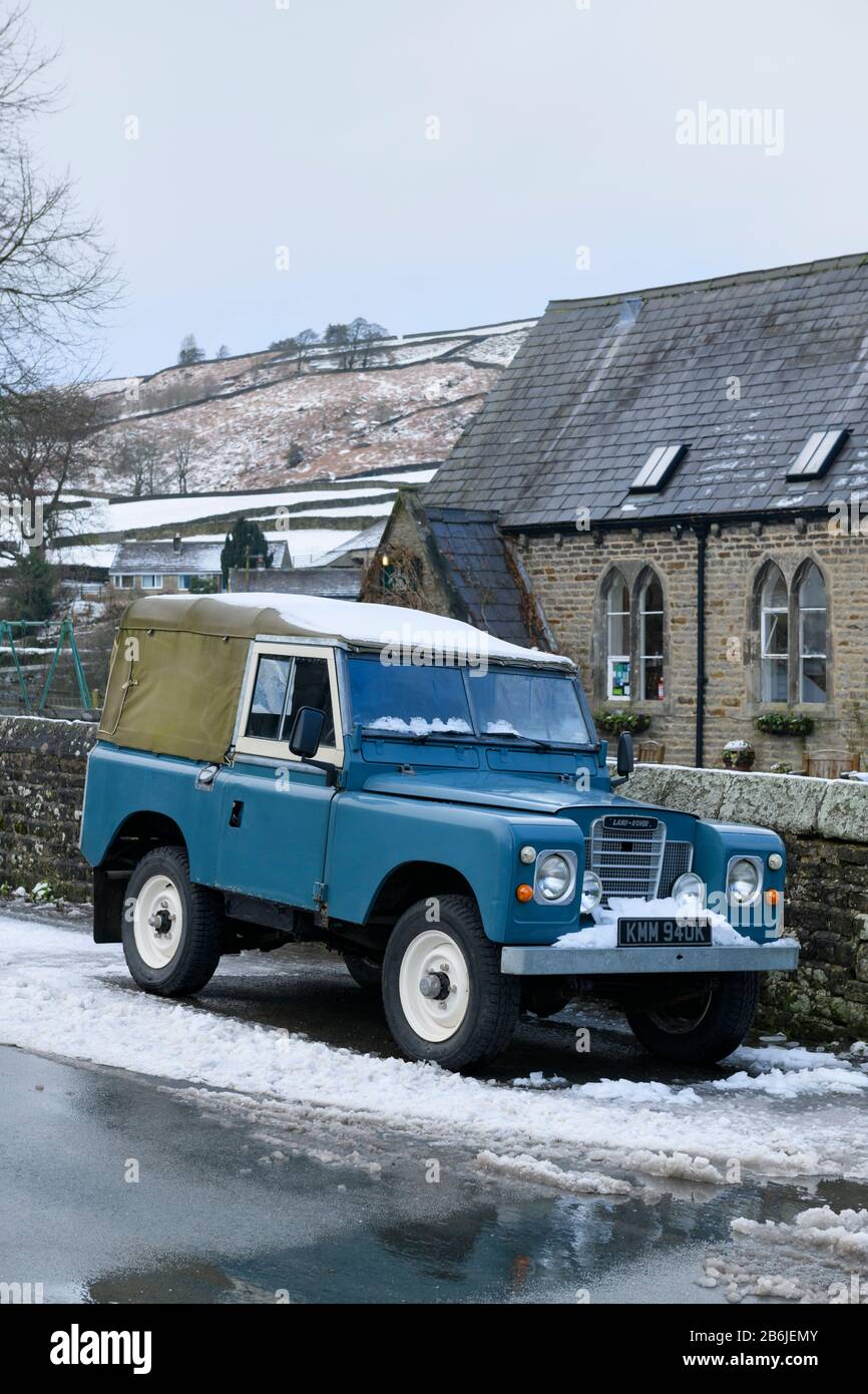 Classico iconico fuoristrada 4x4 Land Rover serie 3 blu, parcheggiato nella neve d'inverno in un villaggio panoramico - Hebden, Yorkshire Dales Inghilterra, Regno Unito. Foto Stock